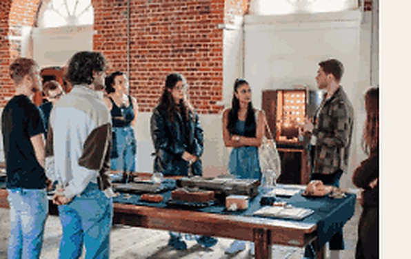 A small group gathered around a table during a Play Office artist development session inside Boathouse 5.